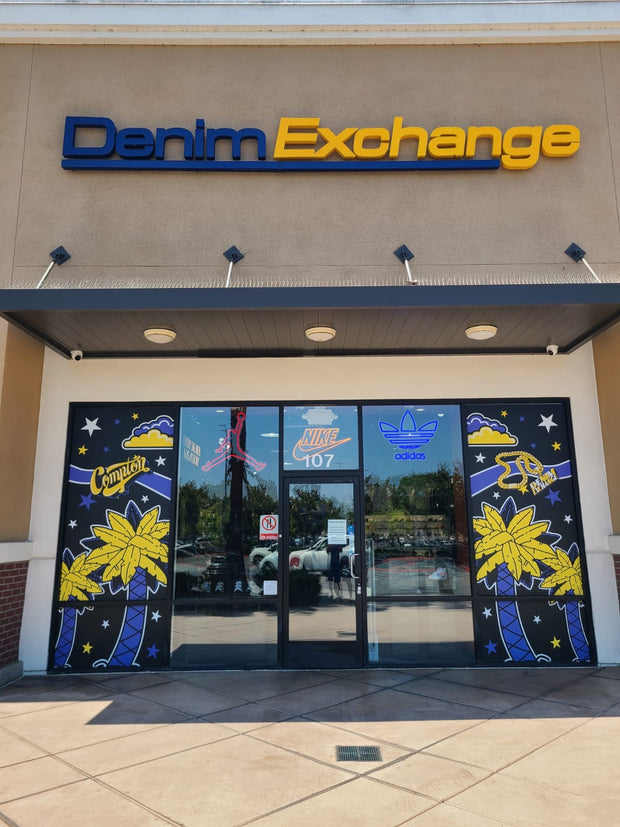 Denim Exchange storefront with branded mural and glass entrance doors