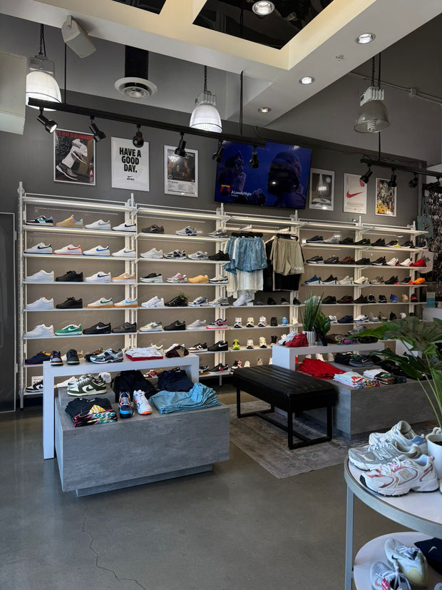 Modern sneaker store interior with wall of shoes and apparel displays