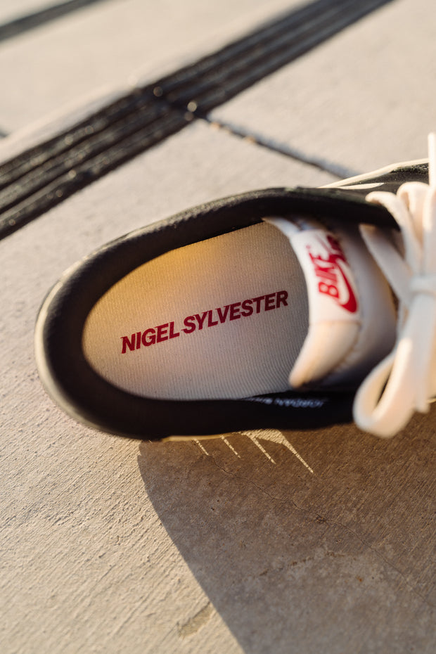 Nigel Sylvester branded insole on black Nike SB Dunk Low sneaker