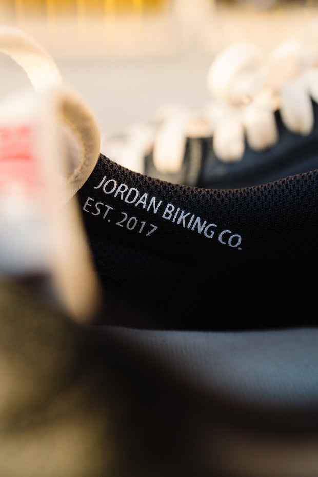 Close-up of sneaker collar label reading "Jordan Biking Co. EST. 2017"