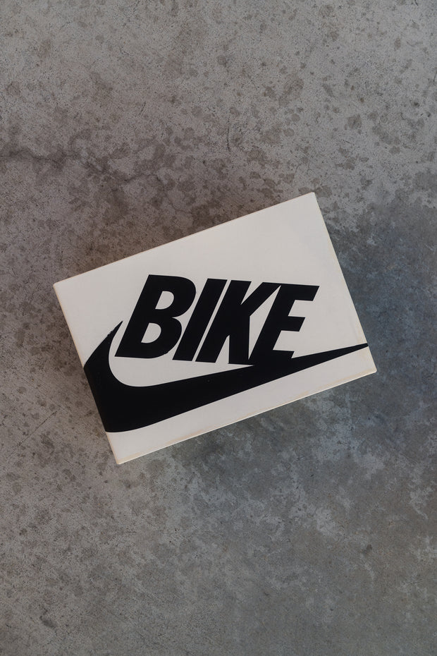 Nike SB "BIKE" shoebox on concrete surface, top view