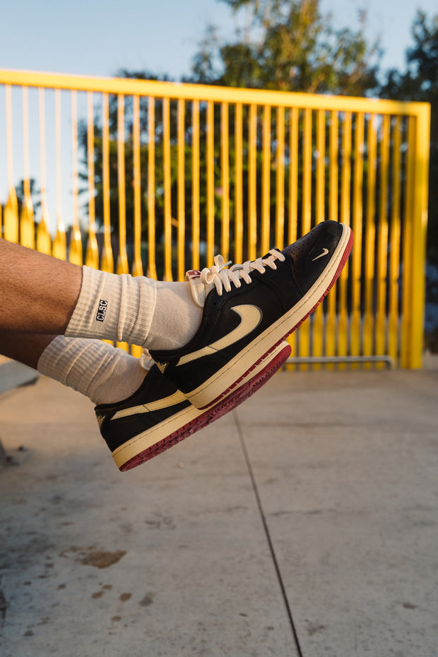 Black vintage Nike sneakers on feet with cream swoosh and red sole
