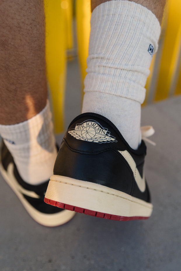 Close-up of Air Jordan 1 Low sneaker heel in black with cream midsole and red outsole
