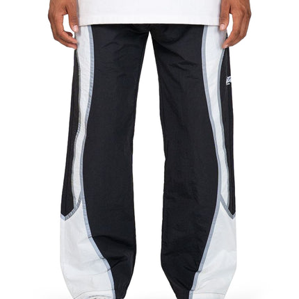 EPTM Cloud nylon joggers in black with wide white curved side panels, loose fit, and elastic cuffs on white sneakers.