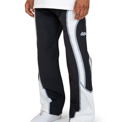EPTM Cloud track pants in black and white with a wide-leg nylon finish, styled with white sneakers against a background.