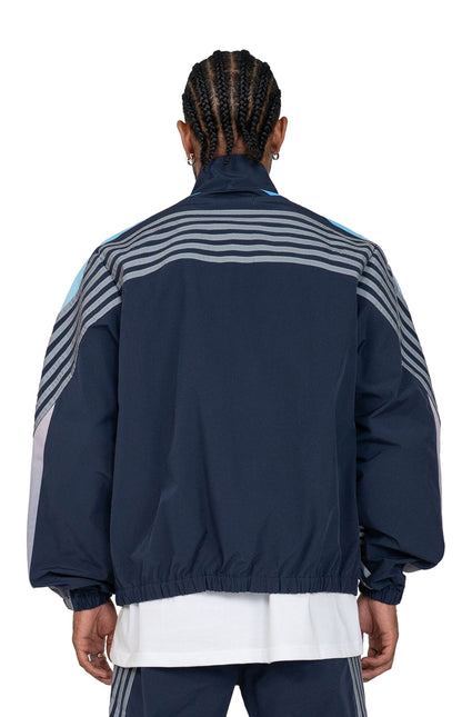 Back view of the navy EPTM Proxy Jacket featuring grey striped sleeve detailing and a smooth windbreaker finish.