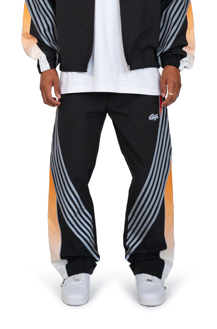 EPTM Proxy track pants in black with prominent silver reflective arched stripes and orange gradient side panel detailing.
