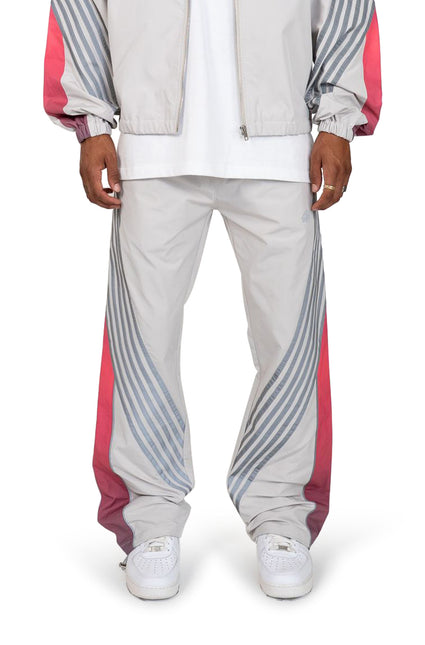 EPTM Proxy track pants in grey featuring a relaxed nylon fit with diagonal reflective stripes and red side panels.