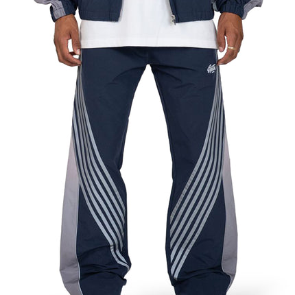EPTM Proxy track pants in navy featuring grey side panels and sweeping diagonal striped detailing on both legs.