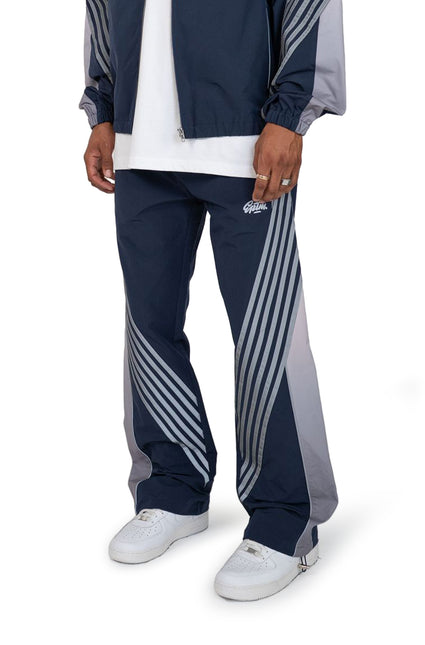 EPTM Proxy pants in navy featuring a loose fit, matte nylon finish, and distinctive grey diagonal stripe detailing.