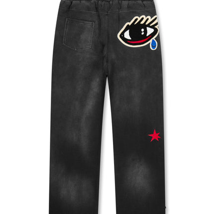 All Human Spitfire V2 sweatpants in washed black cotton featuring a large embroidered eye graphic and a red star.