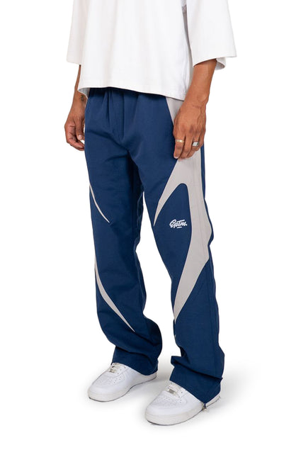 EPTM Blade pants in navy blue cotton with a large silver-grey curved panel detail on each leg and brand logo print.
