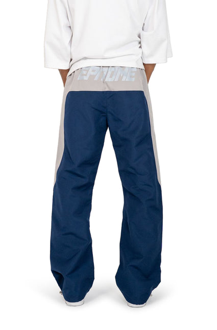 Back view of EPTM Blade pants in navy blue with a light grey waistband featuring large reflective branding text.