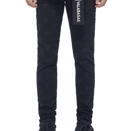 Valabasas Caelune black skinny jeans featuring an all-over embossed logo pattern and a branded rectangular belt tag.