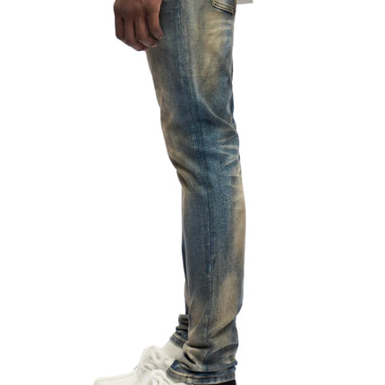 Trnchs Monarch skinny fit jeans in a dark blue dirty wash with subtle distressed finish, viewed from the side profile.