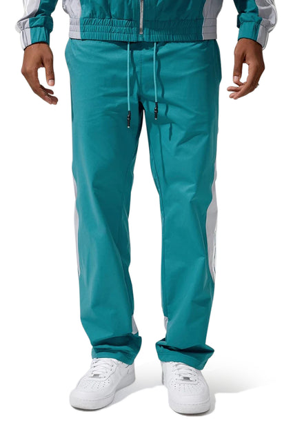 Jordan Craig teal athletic tracksuit pants featuring white side panels, an elastic drawstring waist, and straight fit.