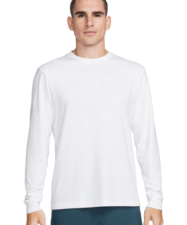 Front view of a man wearing a plain white long-sleeve t-shirt and teal shorts.