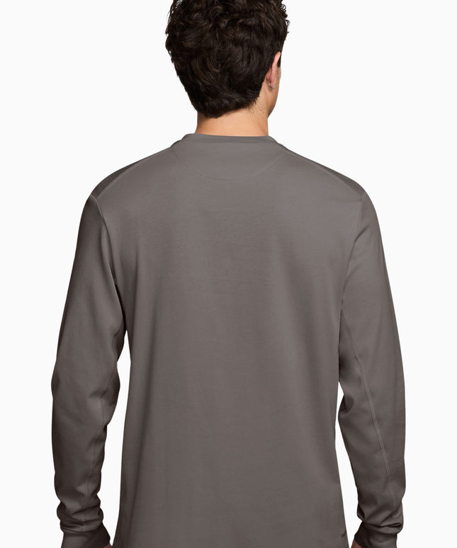 A man viewed from the back wearing a dark gray long-sleeve crewneck shirt, set against a plain white background.