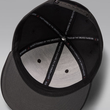 Interior of a black Jordan cap showing branded tape with the text Quality Inspired By The Greatest Player Ever.