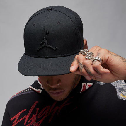 Black Jordan brand snapback hat featuring a tonal embroidered Jumpman logo on a textured cotton fabric finish.
