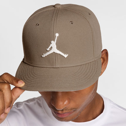 Jordan Jumpman flat-brim baseball cap in earth-toned khaki fabric with a prominent white embroidered logo centered.