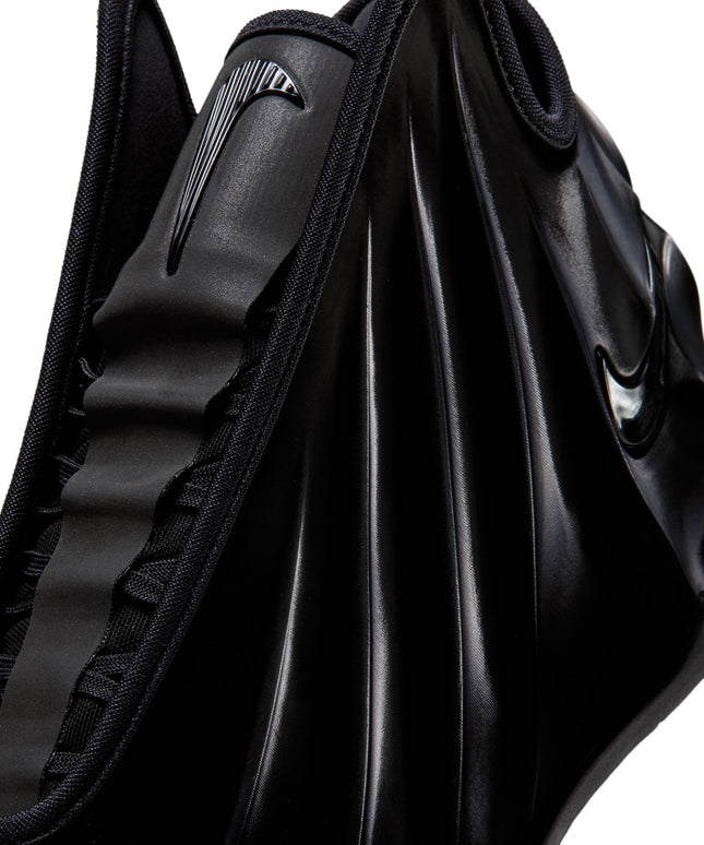 Close-up of a triple black Nike G.T. Future sneaker featuring a sleek, molded foam upper and a glossy swoosh logo.