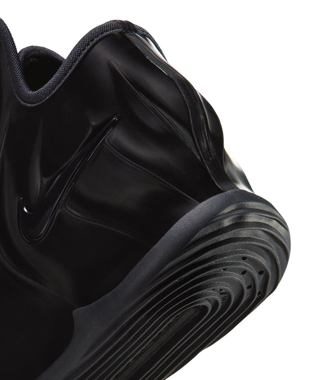 Close-up of the black shiny molded upper and textured rubber outsole of a Nike G.T. Future Triple Black mens sneaker.