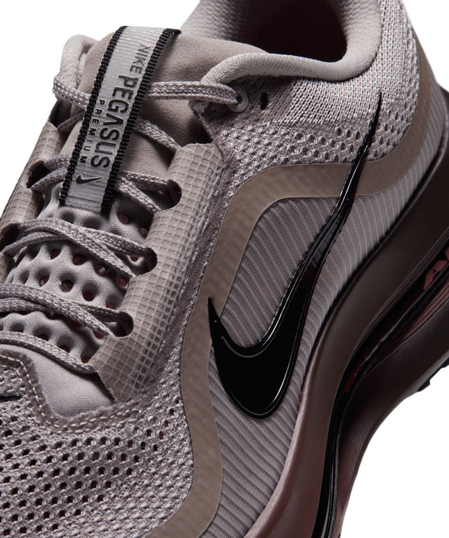 Close-up of Nike Pegasus Premium sneaker in college grey mesh with a glossy black Swoosh and redwood midsole.