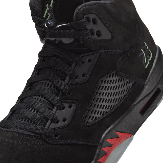 Black suede Air Jordan 5 Retro high-top sneaker with a black mesh side panel, green 23 embroidery, and red flame detail.