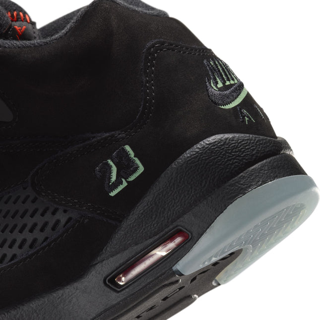 Close-up heel of black suede Air Jordan 5 Retro GS with light green 23 embroidery, translucent outsole, and red Air unit.