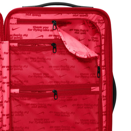 Interior view of a University Red Nike carry-on suitcase featuring branded mesh pockets and zippered compartments.