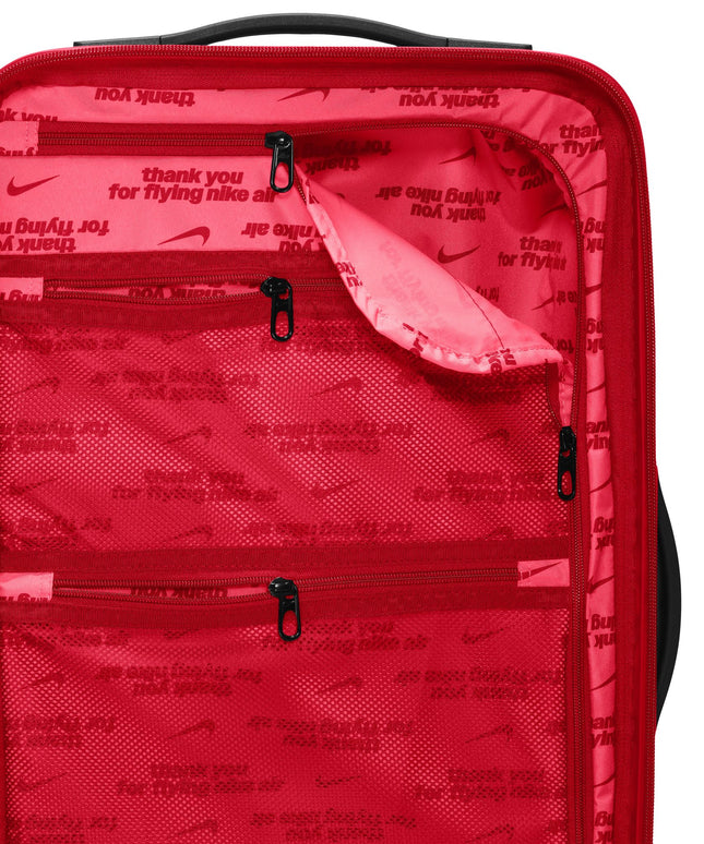 Interior view of a University Red Nike carry-on suitcase featuring branded mesh pockets and zippered compartments.