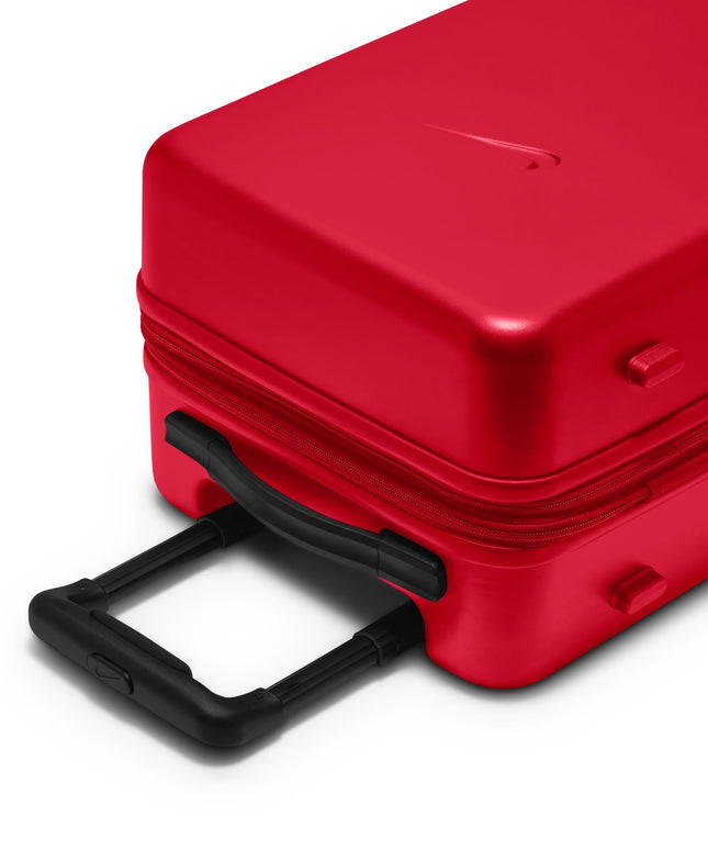 Bright red Nike carry-on luggage with a smooth, hard-shell finish and a black extendable handle, viewed from an angle.
