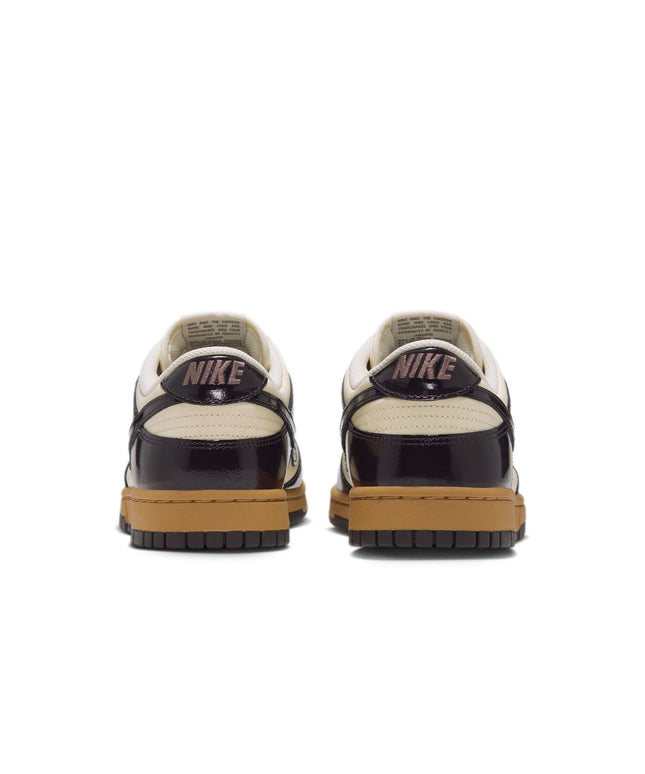 Rear view of Nike Dunk Low Retro sneakers featuring glossy dark brown patent leather overlays and coconut milk base.