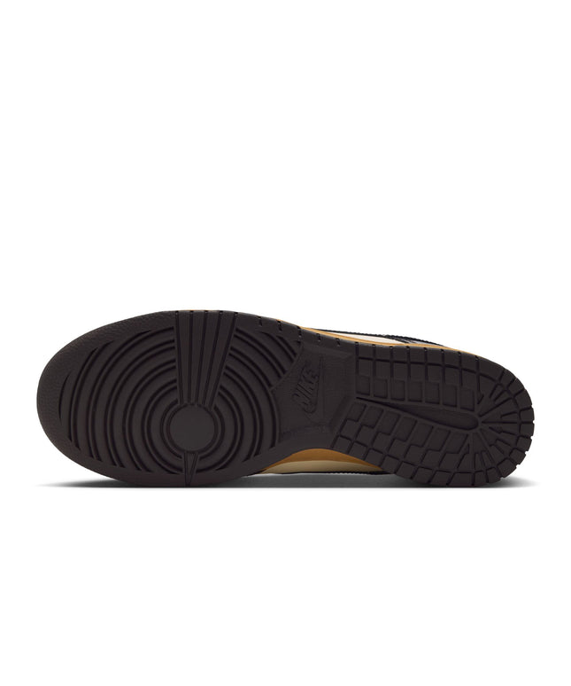 Bottom view of a Nike Dunk Low Retro sneaker featuring a dark brown rubber outsole with a textured grip pattern.