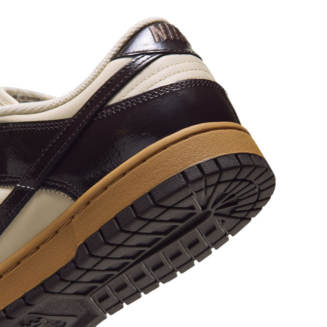 Close-up of the heel on a Nike Dunk Low featuring dark brown patent leather overlays and a smooth coconut milk base.