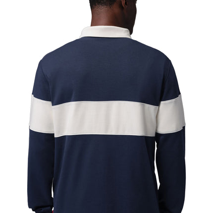 Back view of a man wearing a navy blue Nike Jordan long-sleeve cotton rugby shirt featuring a wide white chest stripe.
