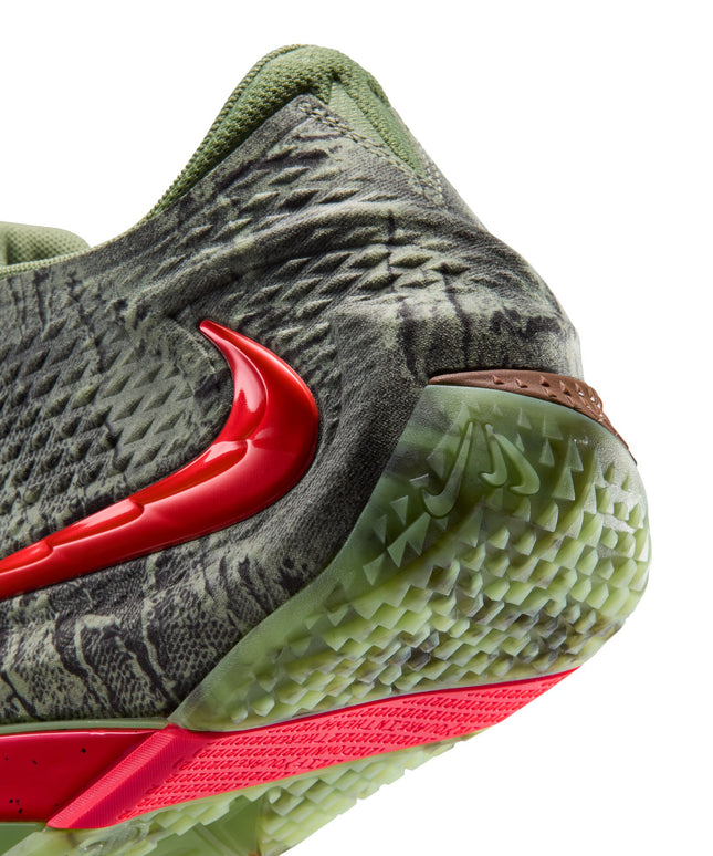 Close-up of Nike Ja 4 Halloween sneaker heel in oil green textured material with a glossy red swoosh and neon base.