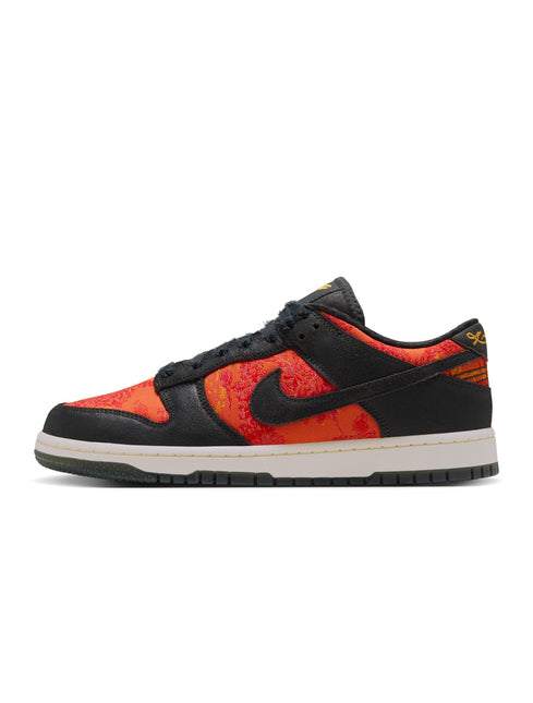 Nike Dunk Low Protro sneaker in black leather with vibrant orange patterned textile panels and a cream rubber outsole.
