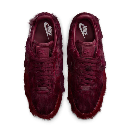 Pair of Nike Air Force 1 sneakers in team red featuring a shaggy, textured faux fur upper, viewed from above.
