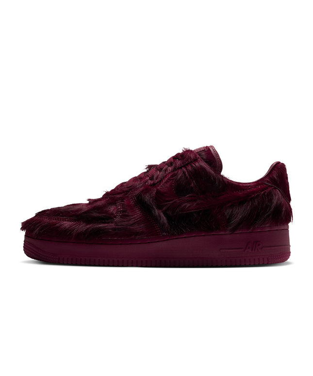 Nike Air Force 1 low-top sneaker in team red faux fur with a matching tonal midsole, shown from a side profile view.