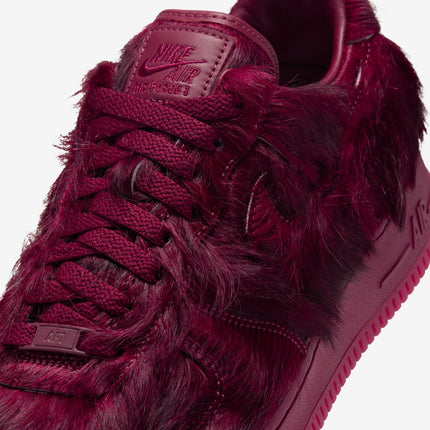 Nike Air Force 1 low-top sneaker featuring a rich team red monochromatic colorway with a unique shaggy faux fur texture.