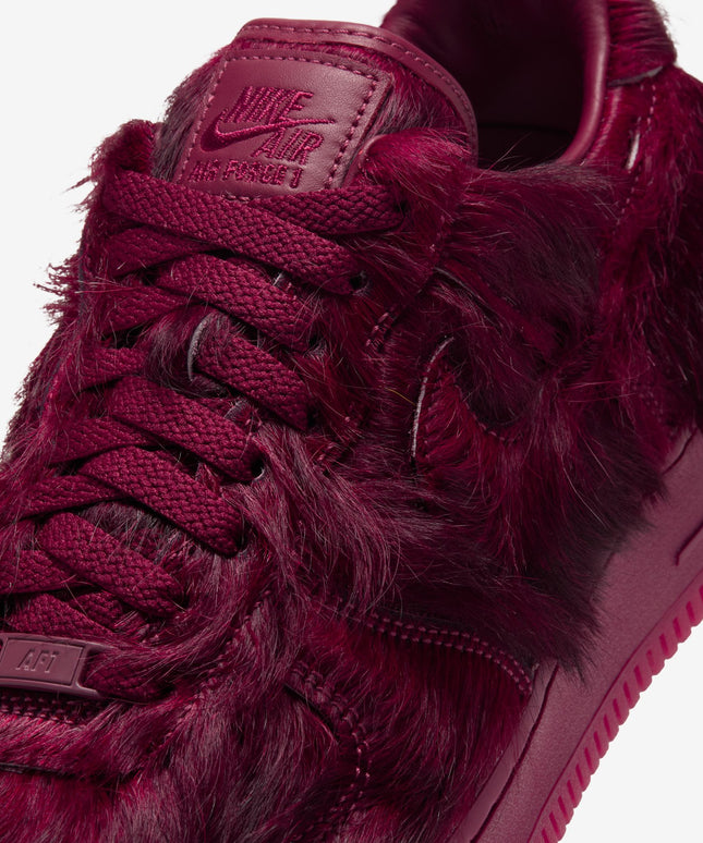 Nike Air Force 1 low-top sneaker featuring a rich team red monochromatic colorway with a unique shaggy faux fur texture.