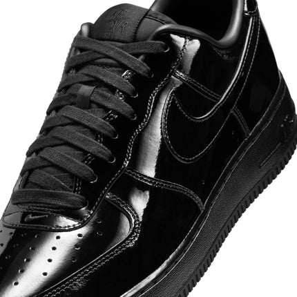 Close-up of a black Nike Air Force 1 '07 sneaker featuring a glossy, high-shine patent leather finish throughout.
