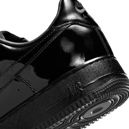 Close-up of a black patent leather Nike Air Force 1 '07 sneaker, highlighting the textured midsole and AIR branding.