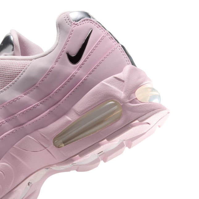 Close-up of a pink foam Nike Air Max 95 sneaker featuring a metallic silver swoosh and glossy chrome heel detailing.