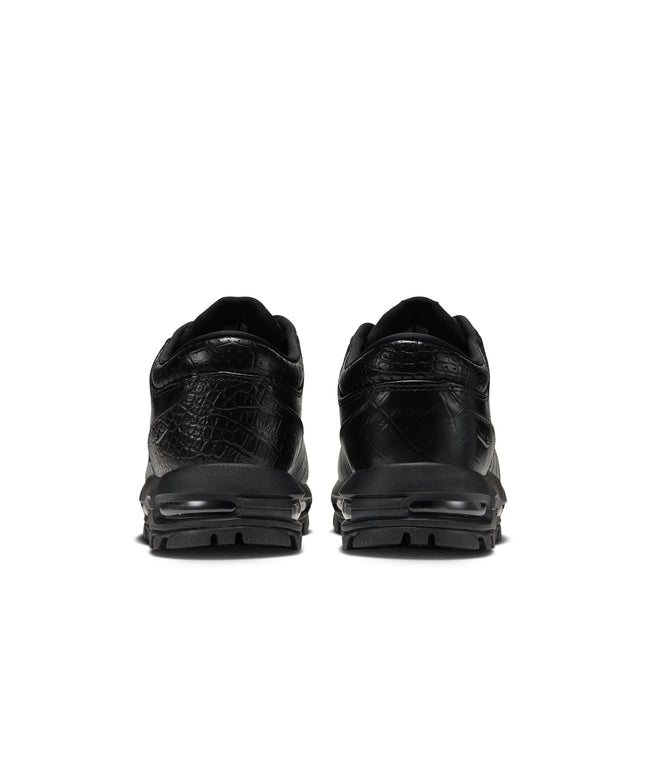 Rear view of black Nike Air Max Goadome Low sneakers featuring crocodile-embossed leather and durable rubber soles.