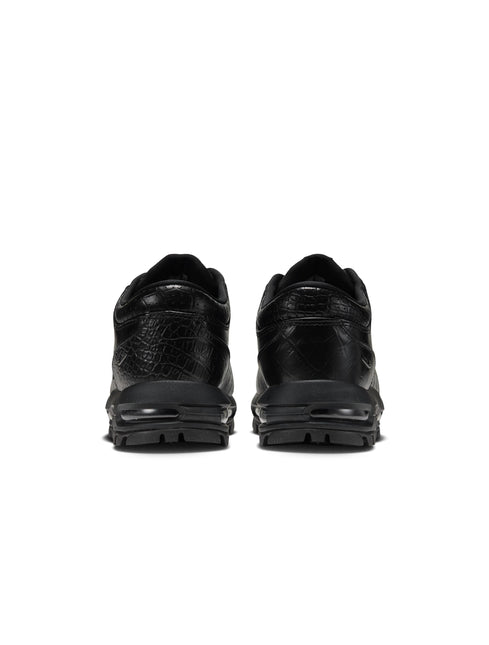 Rear view of black Nike Air Max Goadome Low sneakers featuring crocodile-embossed leather and durable rubber soles.