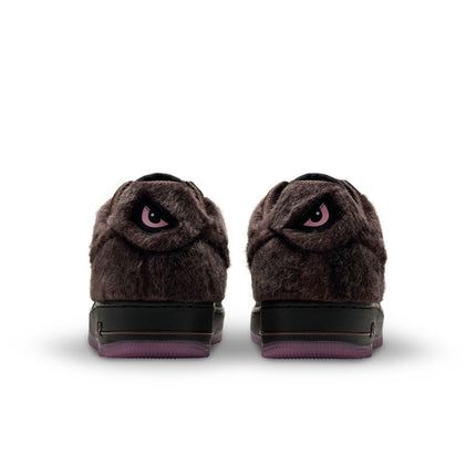 Rear view of Nike Air Force 1 Low sneakers in baroque brown faux fur with pink angry eye graphics on the heel tabs.