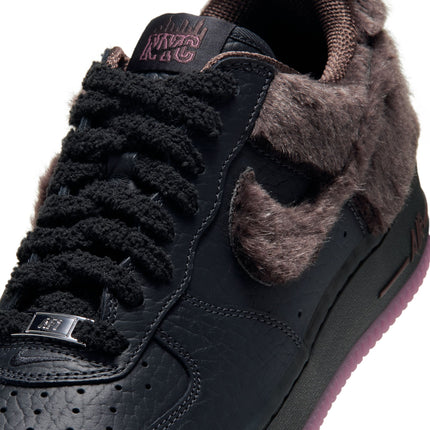 Nike Air Force 1 Low Retro in black leather with brown faux fur side Swoosh, textured black laces, and NYC tongue tag.